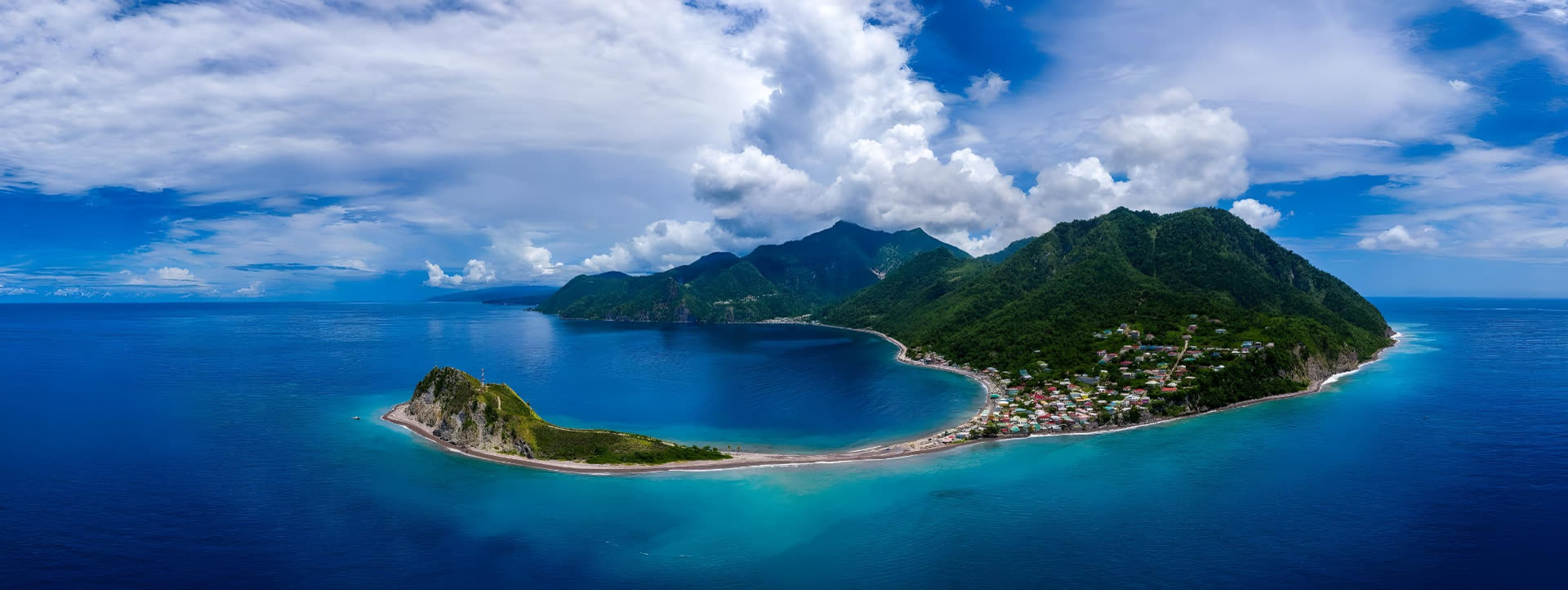 Aerial panorama of Scotts Head with a turquoise Caribbean bay and green mountains
