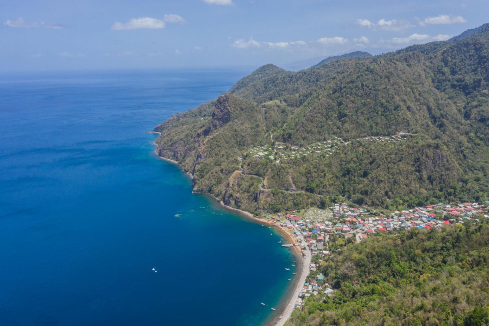 Aerial view of Dominica's southwest coast with Soufrière village nestled between the sea and forested hills